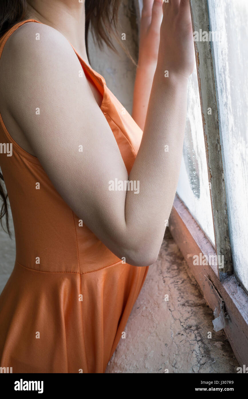 Profil einer jungen Frau, die durch die Fenster Hände berühren des Glases stehen Stockfoto