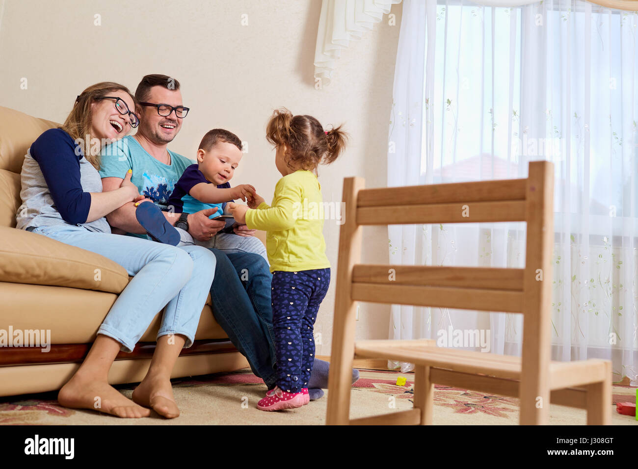 Eltern und Kinder glücklich Lachen im Zimmer ihres Hauses Stockfoto