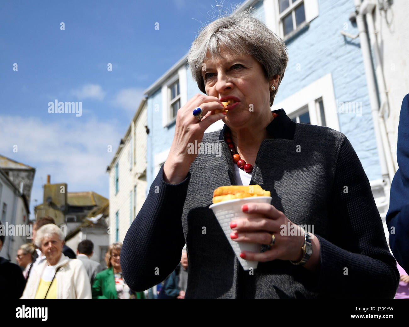 Premierminister Theresa Mai haben einige Chips auf einem Rundgang während einer Wahlkampagne in Mevagissey, Cornwall zu stoppen. Stockfoto