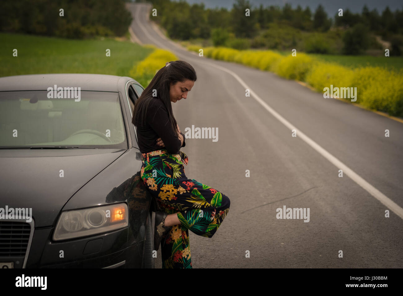 Frau mager auf dem Auto Stockfoto