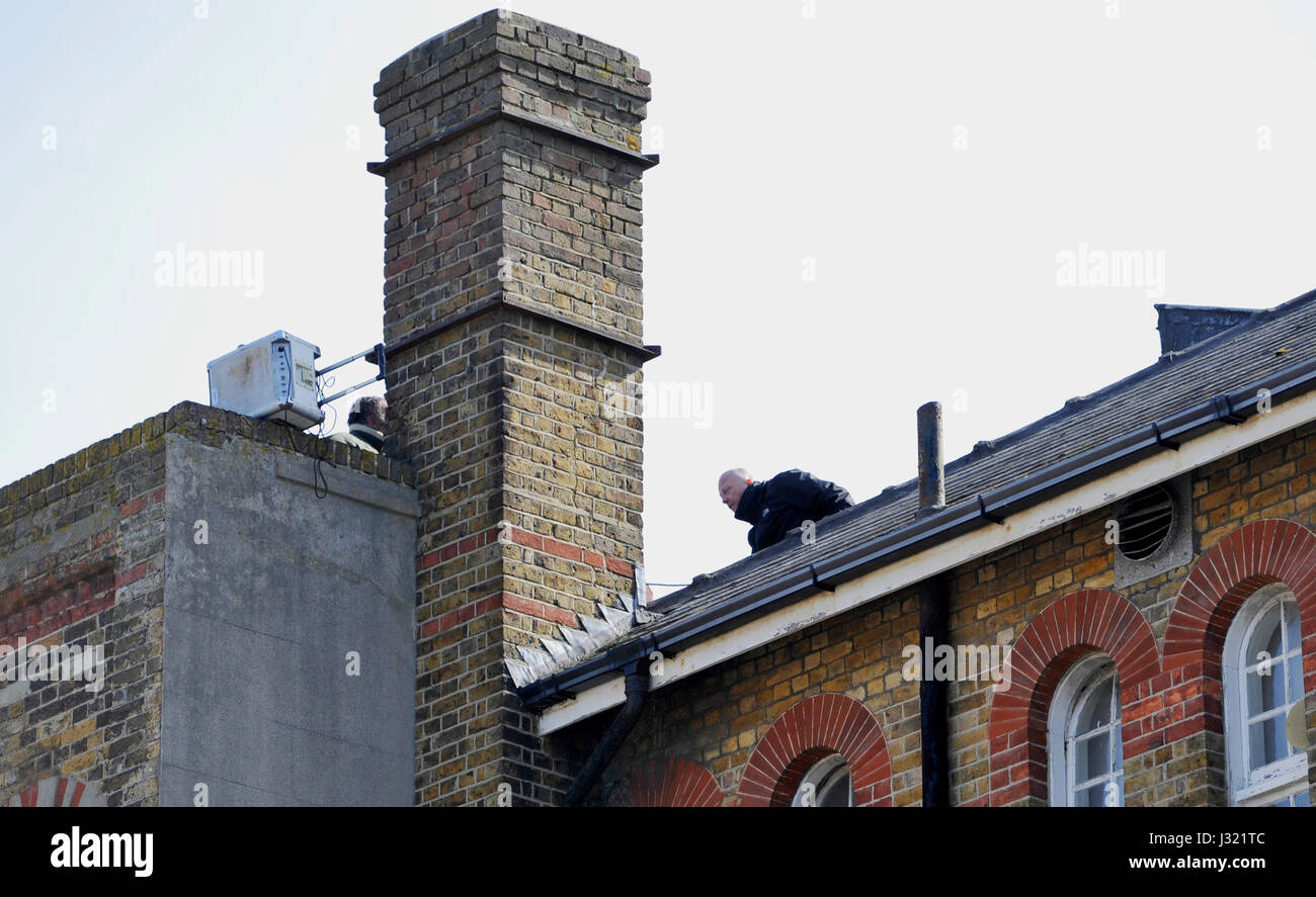 Brighton, UK. 2. Mai 2017. Mitglied des Sicherheitspersonals versuchen, sprechen ein Hausbesetzer in einem auf dem Dach-Protest nach Hausbesetzer aus der University of Brighton ehemaligen Zirkus Straße Gebäude heute vertrieben. Das Gebäude gehört zu einem Sanierungsprojekt im Zentrum Stadt und ist seit einer Weile leer Credit: Simon Dack/Alamy Live News Stockfoto