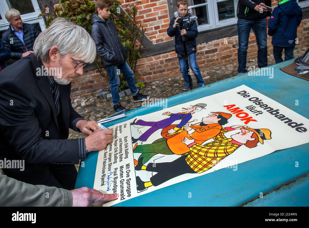 Schwerin, Deutschland. 2. Mai 2017. Jes Holstoe aus Dänemark, der die Teenager Borge in den beliebten dänischen Kriminalität Komödien der Olsen-Bande gespielt, unterschreibt bei der Eröffnung einer Sonderausstellung auf der Filmgeschichte der Olsen-Bande in Schwerin, Deutschland, 2. Mai 2017 ein Filmplakat. Die Bande verwendet einen Chevrolet Bel Air aus dem Jahr 1959 in vielen ihrer Filme. 60-Jahr-alten Holtsoe eröffnet nicht nur die Ausstellung über die Olsenbande-Filme, die in den neuen Bundesländern besonders beliebt waren. Bildnachweis: Dpa picture Alliance/Alamy Live News Stockfoto