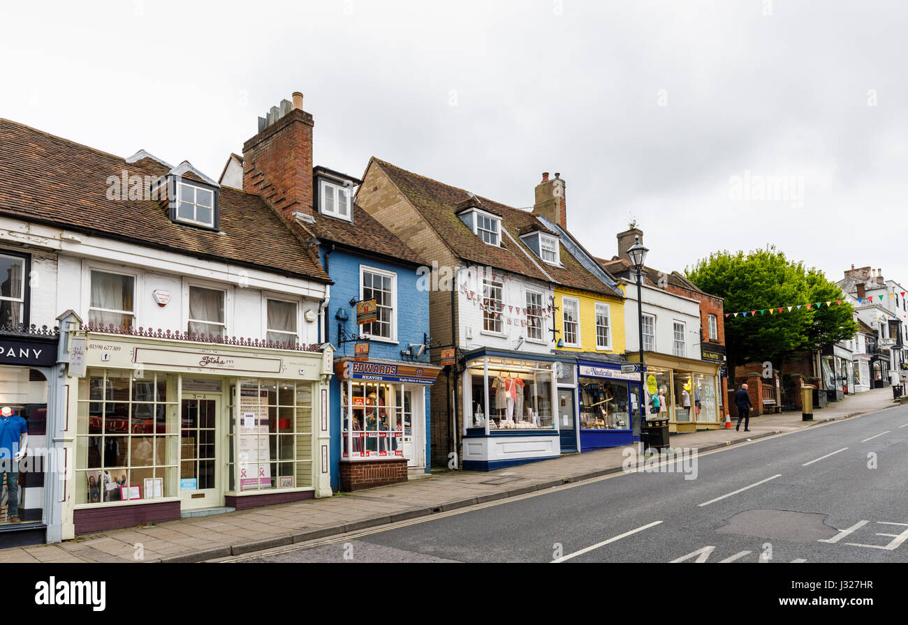 Die steilen Hügel High Street und kleinen bunten Geschäften in der Innenstadt von Lymington, Hampshire, Südküste von England Stockfoto