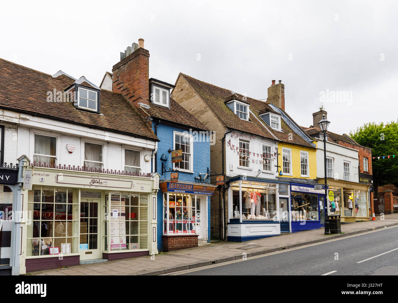 Die steilen Hügel High Street und kleinen bunten Geschäften in der Innenstadt von Lymington, Hampshire, Südküste von England Stockfoto