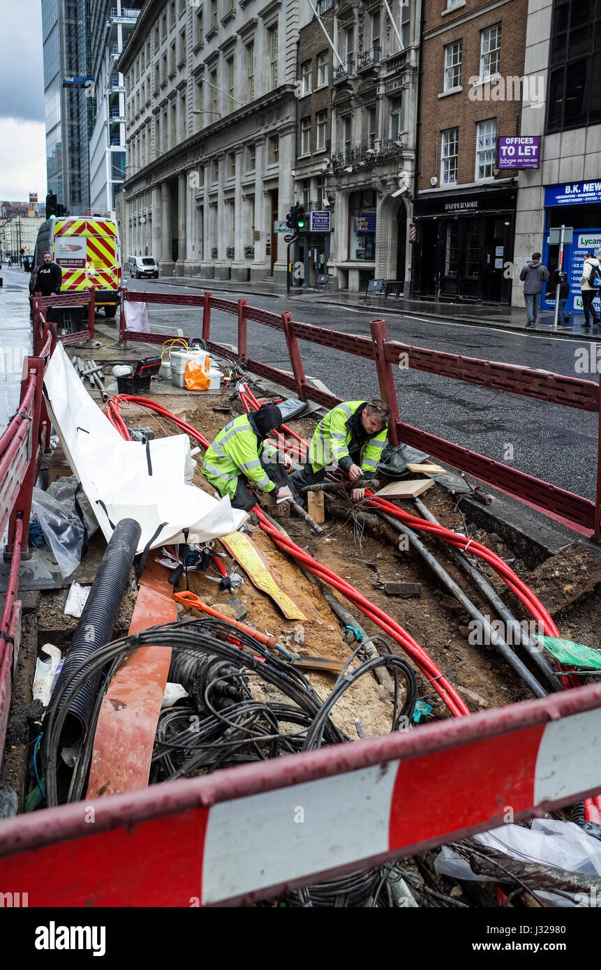 Arbeiter reparieren elektrische Leitungen in Londons Finanzviertel, der Square Mile. Stockfoto