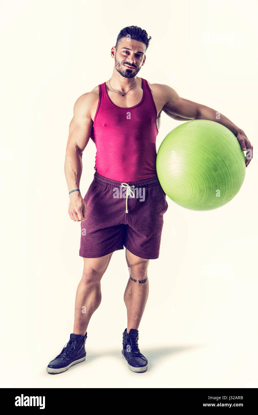 Muskulöser Mann mit aufblasbaren Fitnessball Stockfoto