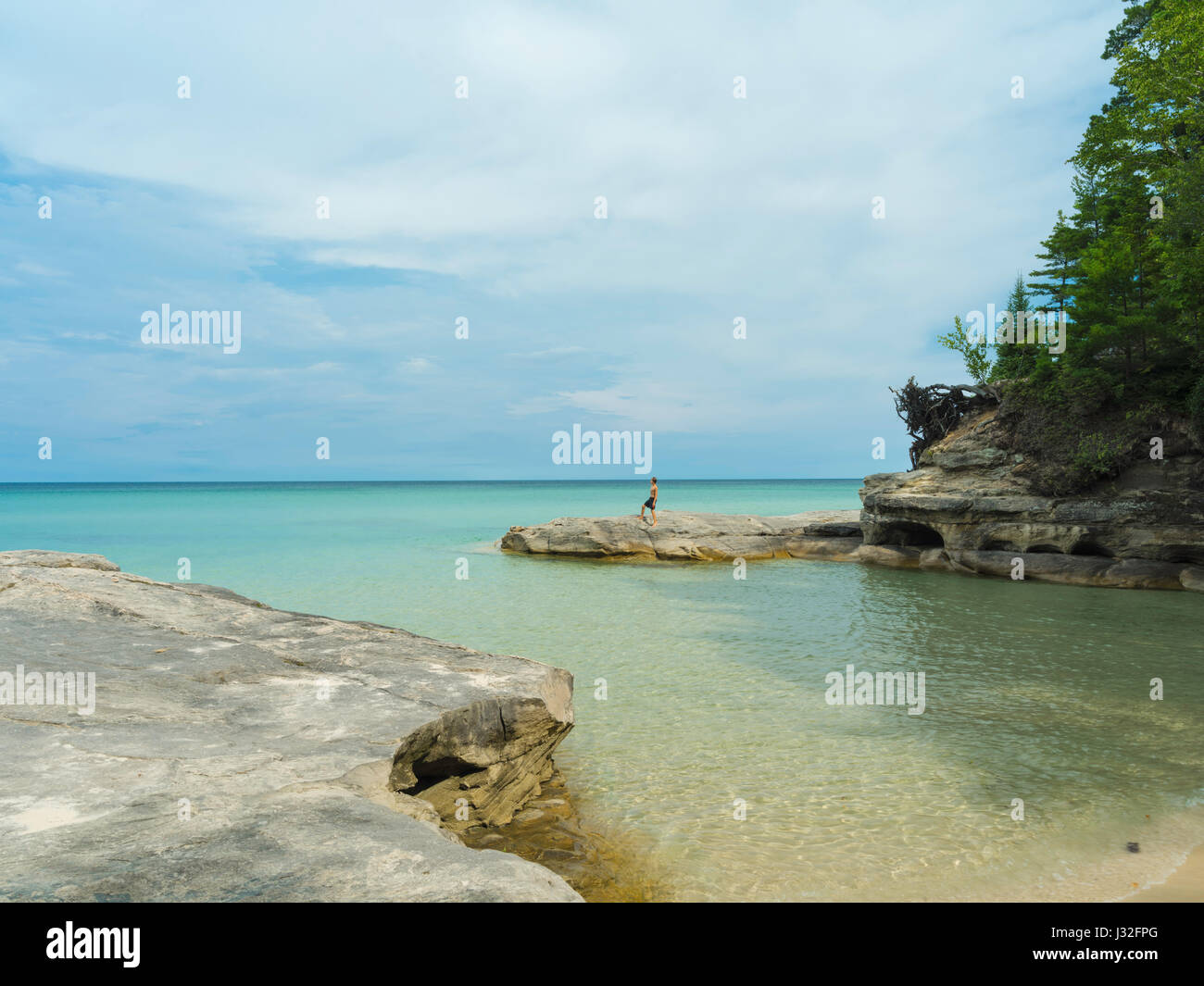 Ein Junge am Lake Superior suchen. Bild aus der Gegend bekannt als "The Cove", dargestellten Felsen National Lakeshore, Michigan, USA. Stockfoto