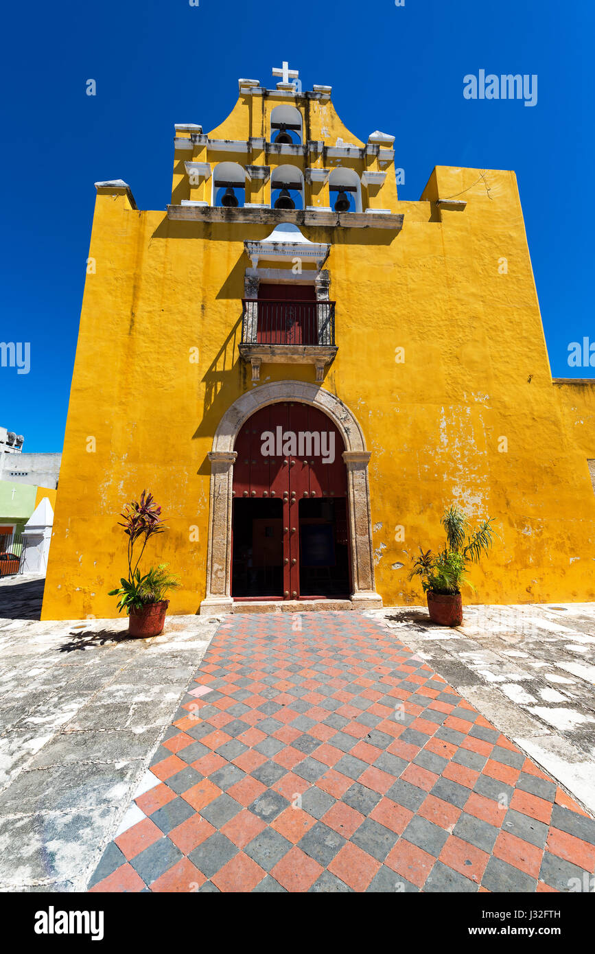 Schöne gelbe kolonialen Kirche mit einem tiefblauen Himmel in Campeche, Mexiko Stockfoto