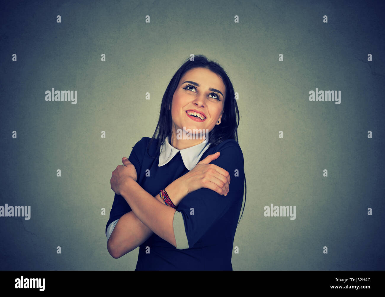 Closeup Portrait zuversichtlich lächelnde Frau halten, umarmen sich isoliert graue Wand Background. Re, Gesichtsausdruck, positive menschliche Emotionen und Gefühl Stockfoto
