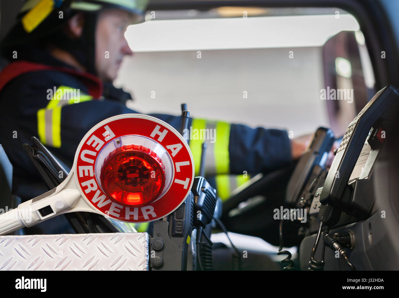 Feuerwehrmann fährt ein Einsatzfahrzeug mit Kommunikation Innenansicht und Kelle Stockfoto