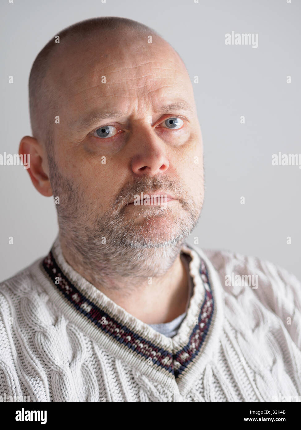 Headshot, lässige suchen Kaukasischen Männchen tragen einen weißen Pullover sieht er in Richtung der Kamera Stockfoto