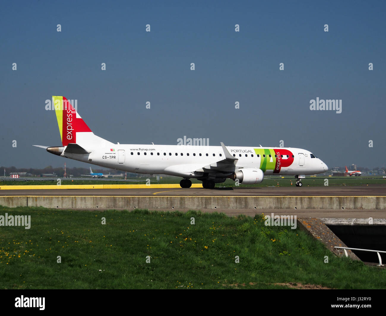 Dieses Bild zeigt ein TAP Express Embraer ERJ-190LR Flugzeug mit der Zulassung CS-TPR am Flughafen Schiphol (AMS) in den Niederlanden, das das moderne Flugzeug am Gate erfasst. Stockfoto