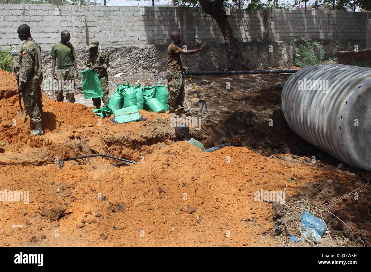 Soldaten aus dem ugandischen Kontingent unter Mission der Afrikanischen Union in Somalia (AMISOM) arbeiten an der Drainage-System von Madina Hospital in Mogadischu auf 5. Februar 2017 als Teil der Tarehe Sita-feiern, die die Bildung von der ugandischen Armee ist die ugandische Menschen Defence Forces (UPDF) am 6. Februar 1981 erinnert. AMISOM Foto / Raymond Baguma Stockfoto