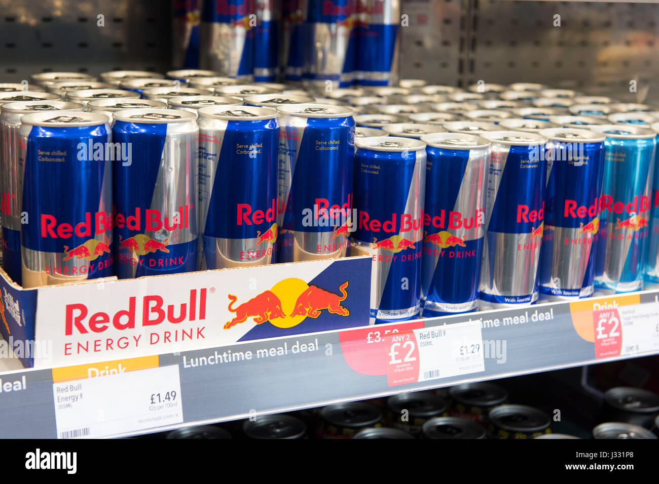 Dosen Red Bull auf der Anzeige für den Verkauf auf einem Regal. Stockfoto