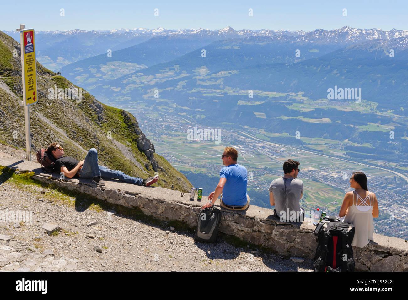 Vier junge Menschen entspannen und genießen Sie den malerischen Blick vom Hefelekar Berg, Tirol, Österreich Stockfoto