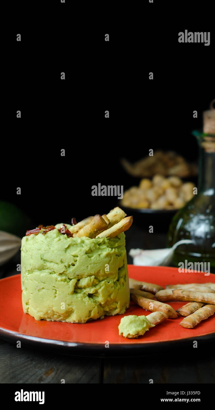 Avocado Hummus mit Mini Grissini, rustikale Stillleben Stockfoto