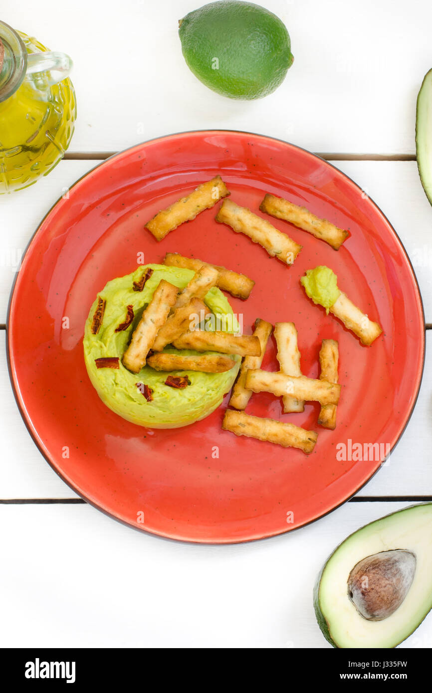 Avocado Hummus mit Mini Grissini, rustikale Stillleben Stockfoto