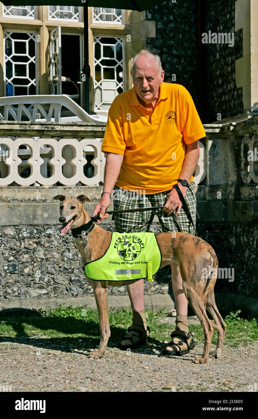 Ältere männliche Freiwillige mit seinem Hund P.A.T. (Tiere als Therapie) Jill Swanbourne See, Arundel, West Sussex im Bild Stockfoto