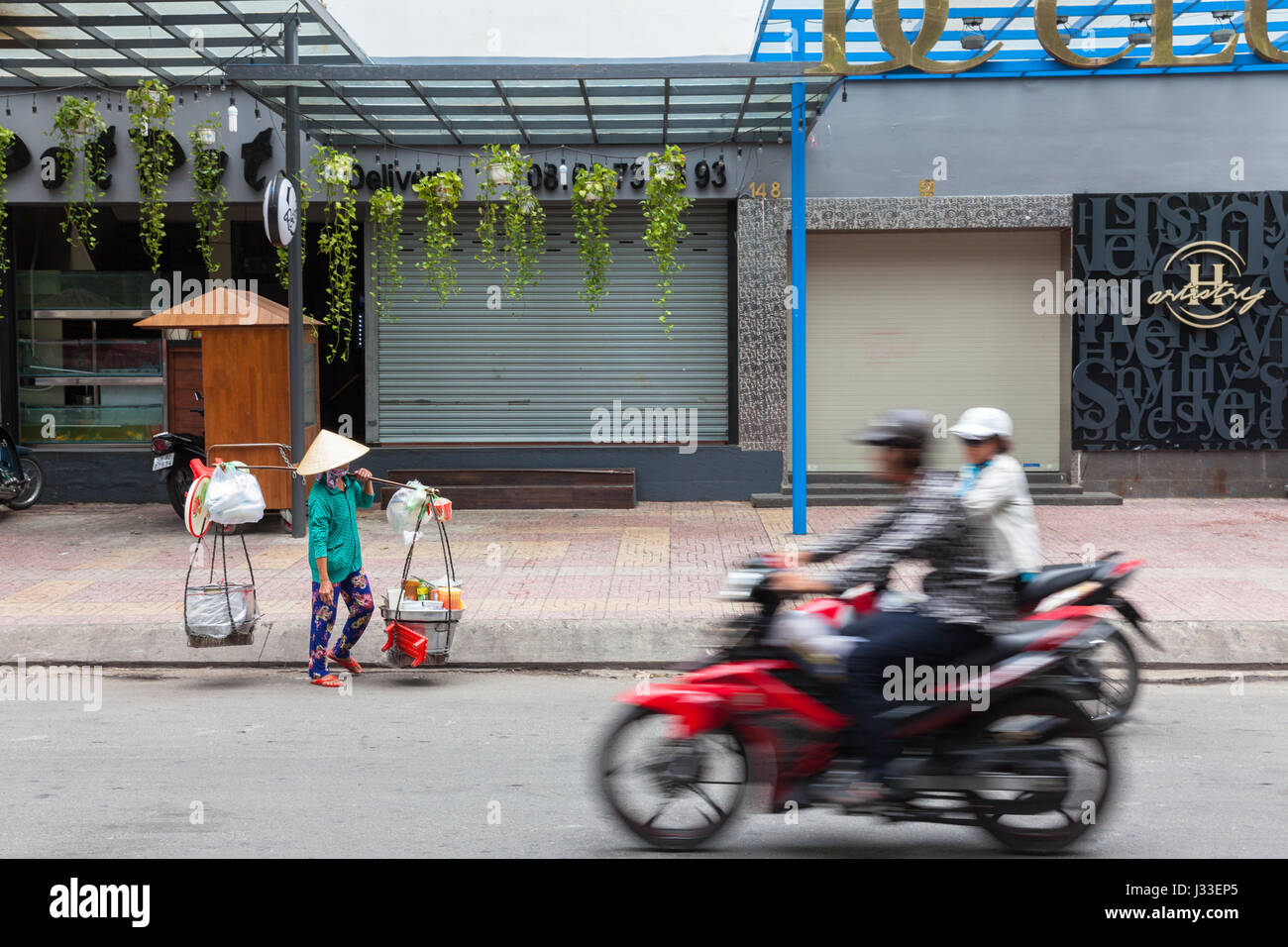HO CHI MINH CITY, VIETNAM - 24. NOVEMBER: Street Essen Anbieter in traditionellen konische Hut am 24. November 2015 in Ho-Chi-Minh-Stadt, Vietnam. Stockfoto