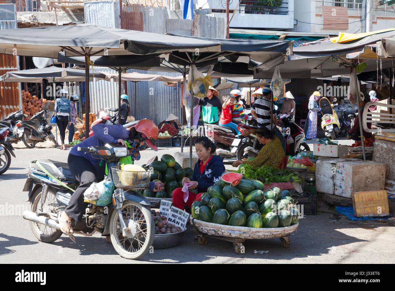 NHA TRANG, VIETNAM - Dezember 12: Frau Star Äpfel und Wassermelonen auf dem nassen Markt am 12. Dezember 2015 in Nha Trang, Vietnam verkauft. Stockfoto