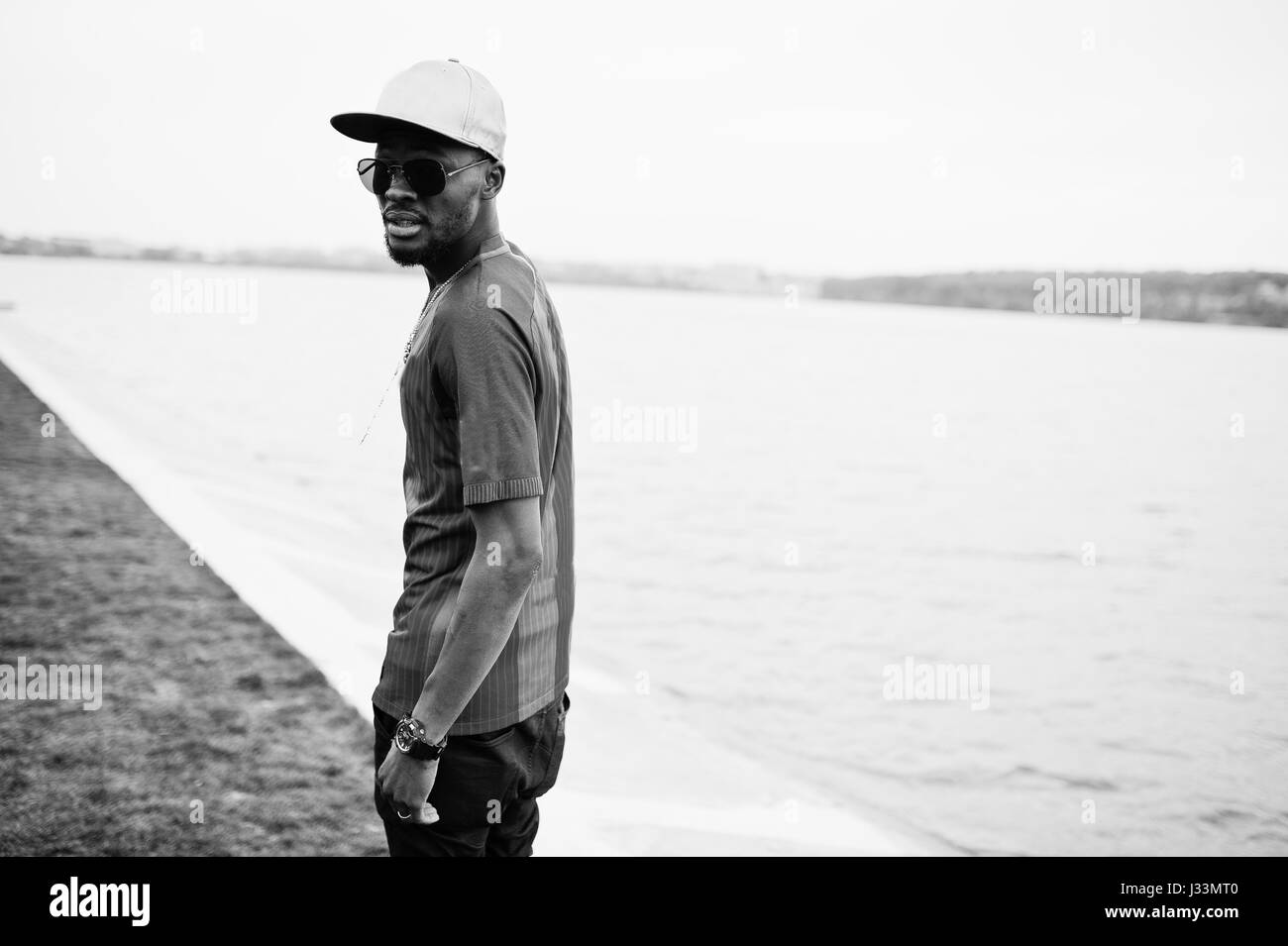 Stilvolle afroamerikanischen jungen Verschleiß am Cap, Fußball T-shirt und Sonnenbrille. Schwarz Sport Mann Porträt. Stockfoto