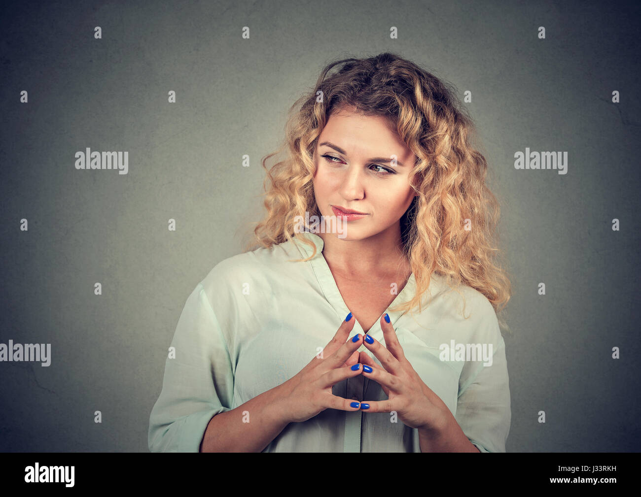 Closeup Portrait hinterhältig, sly, intriganten jungen Frau Plotten etwas isoliert auf grauem Hintergrund. Negative Emotionen, Mimik, Gebühr Stockfoto