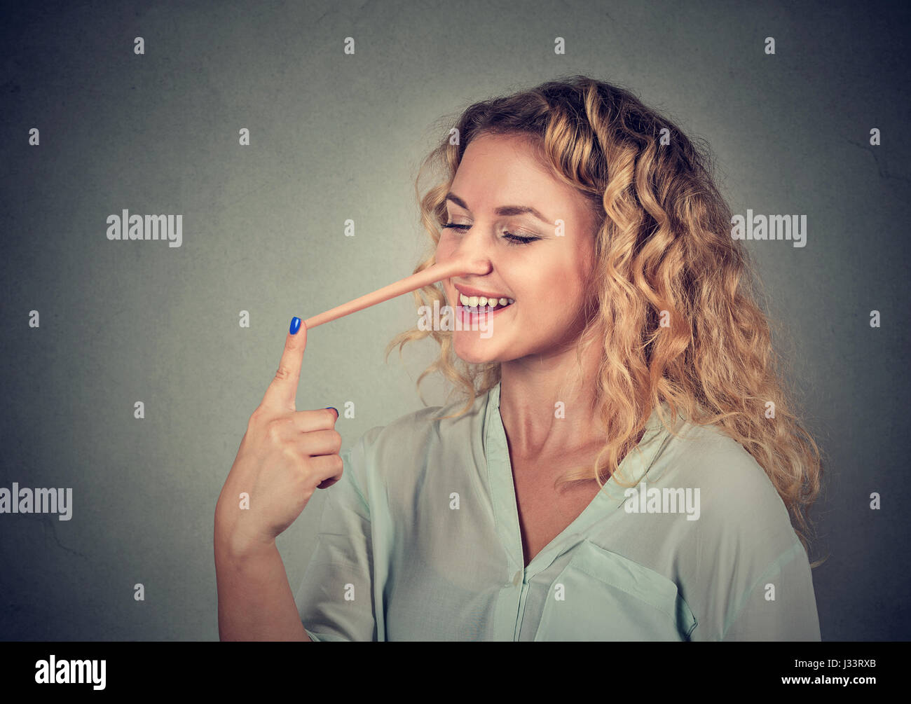 Frau mit langen Nase auf graue Wand Hintergrund isoliert. Lügner-Konzept. Menschlichen Gesichtsausdruck, Emotionen, Gefühle Stockfoto