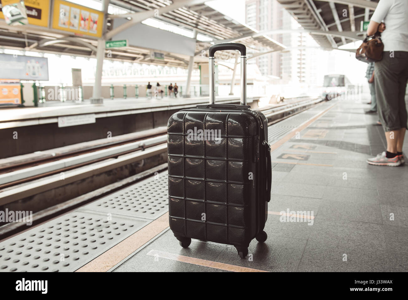 Schwarzen Gepäck wartenden Zug in einer station Stockfoto
