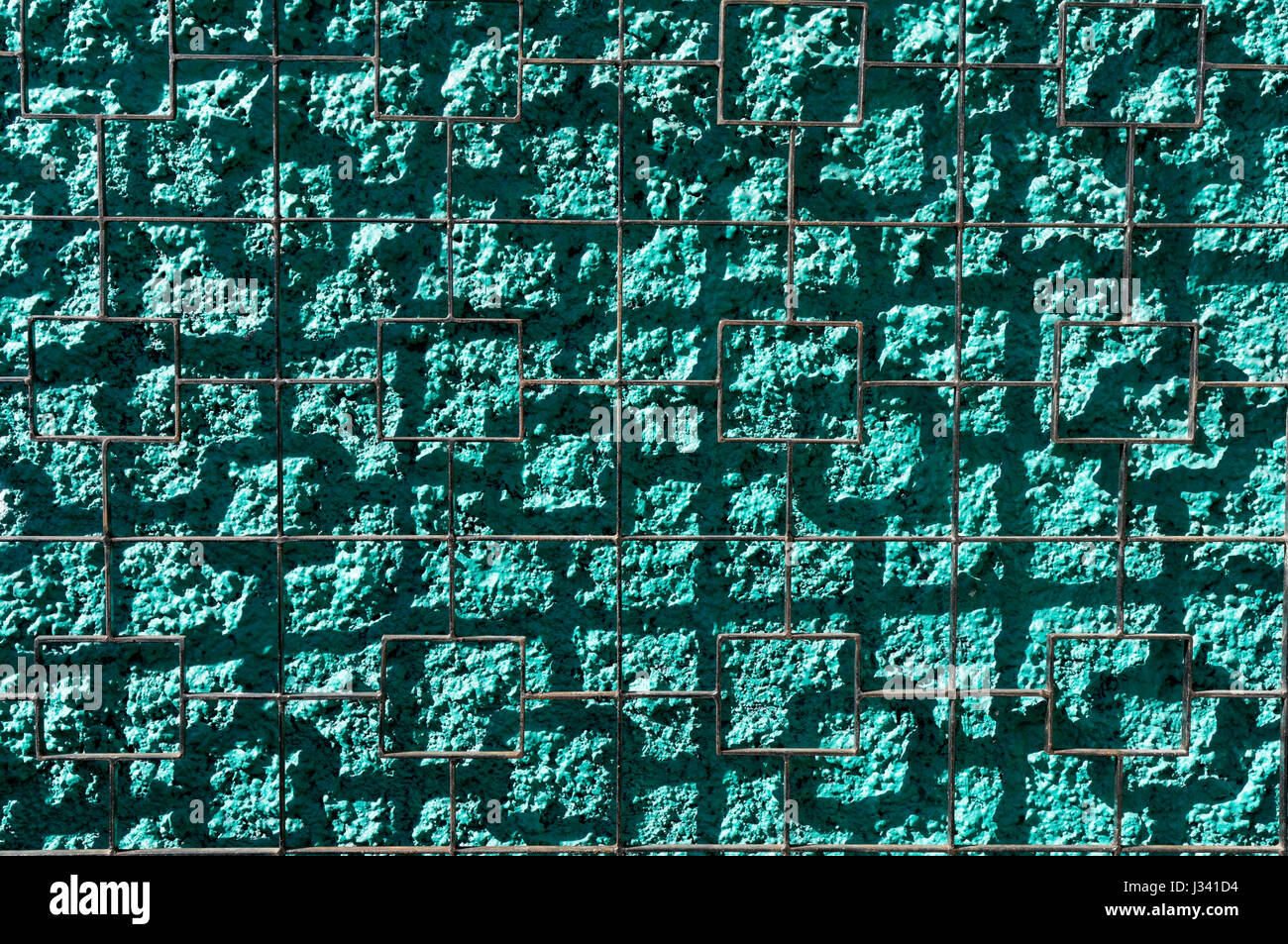 Draht Gitter quadratisch Schattenwurf auf einem hellen grünen Stuck Wand abstrakten Hintergrund Stockfoto
