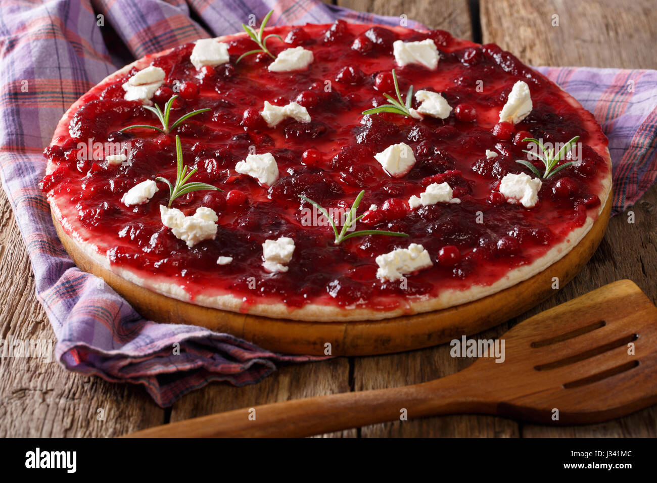 Köstliche pikante Fladenbrot mit Cranberry, Ziege Käse und Rosmarin Nahaufnahme auf einem Brett. horizontale Stockfoto