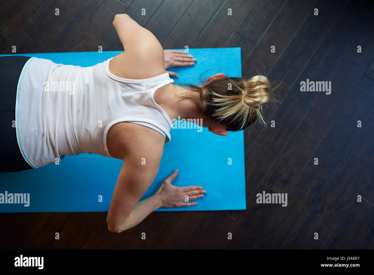 Fit Frau mittleren Alters Liegestütz zu tun, als sie auf einer Matte im Fitnessstudio arbeitet angesehen von oben mit textfreiraum in einem Gesundheits- und Fitness-Konzept Stockfoto