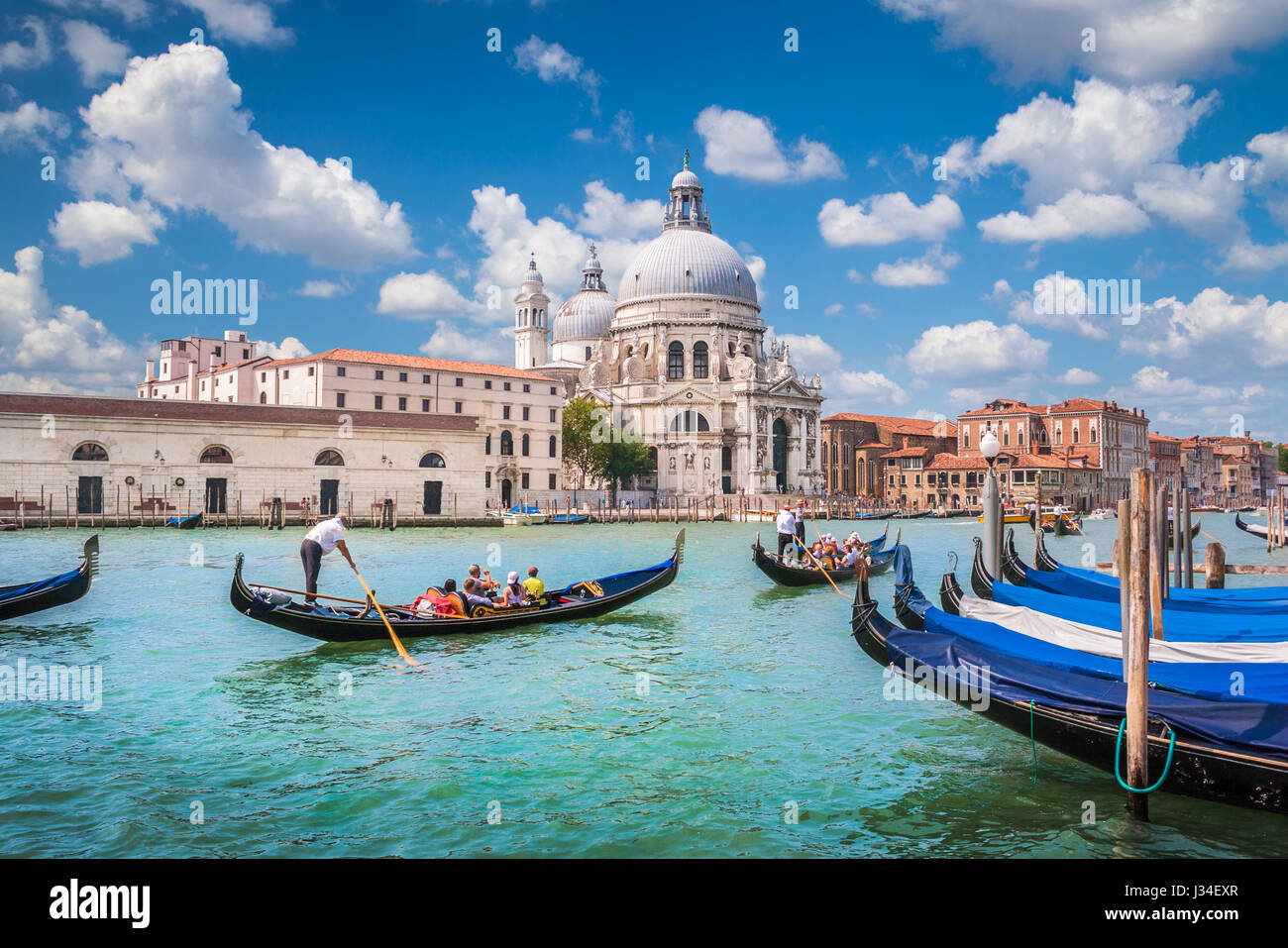 Schöne Aussicht auf traditionellen Gondeln auf dem Canal Grande mit historischen Basilika di Santa Maria della Salute im Hintergrund an einem sonnigen Tag in Venedig Stockfoto