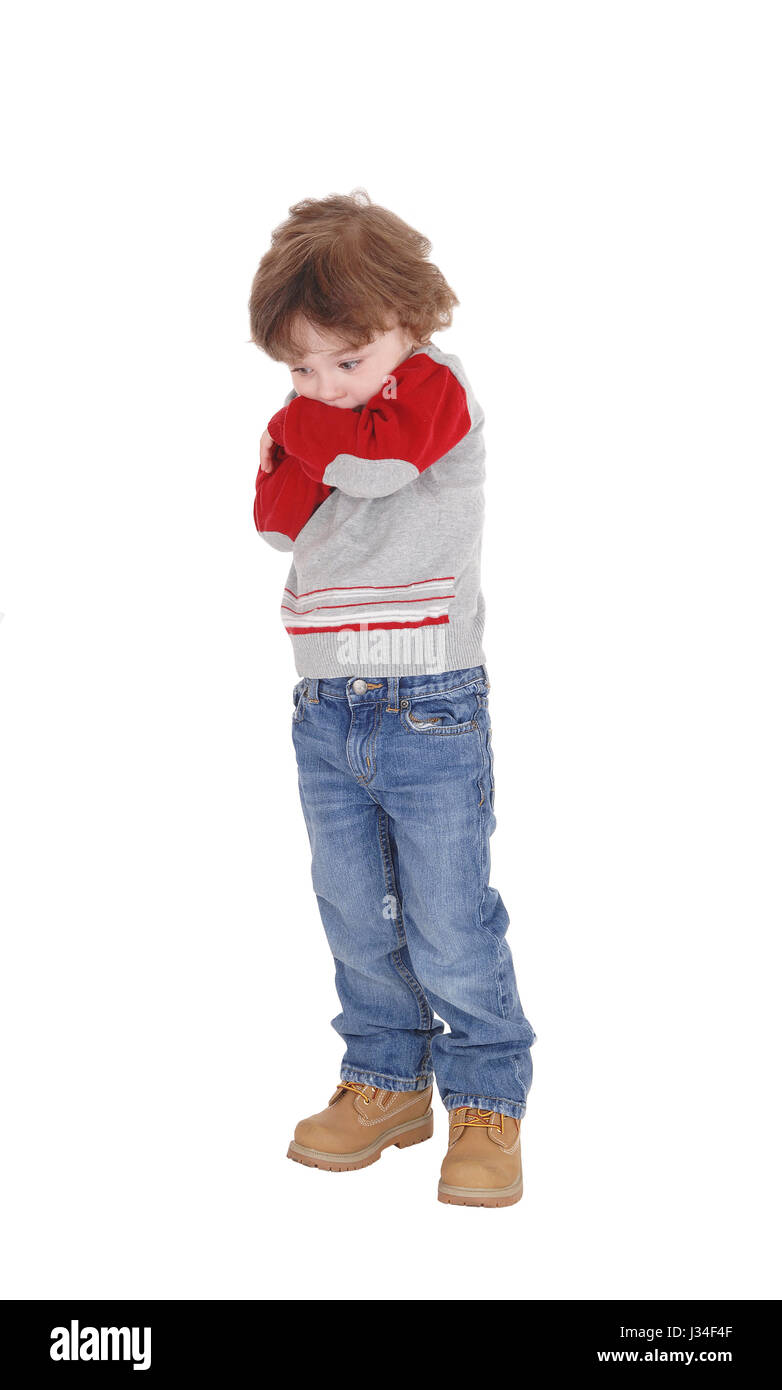 Ein Bild eines kleinen dreijährigen jungen stehend mit seine Arme verschränkt ist er sehr schüchtern, für weißen Hintergrund isoliert. Stockfoto