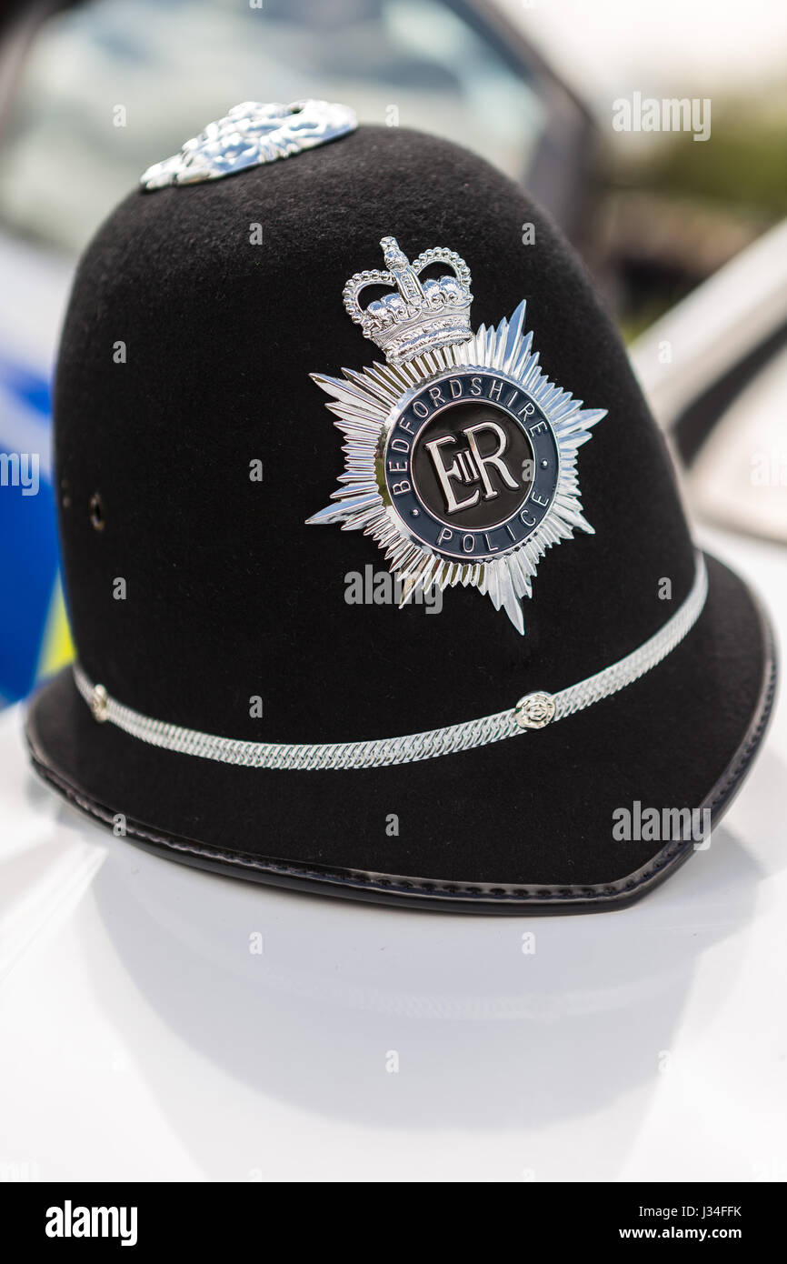 Eine Nahaufnahme von einem traditionellen Bedfordshire Polizisten Helm sitzt auf der Motorhaube von einem Vauxhall Astra Polizei Streifenwagen mit dem Abzeichen knackig scharf Stockfoto