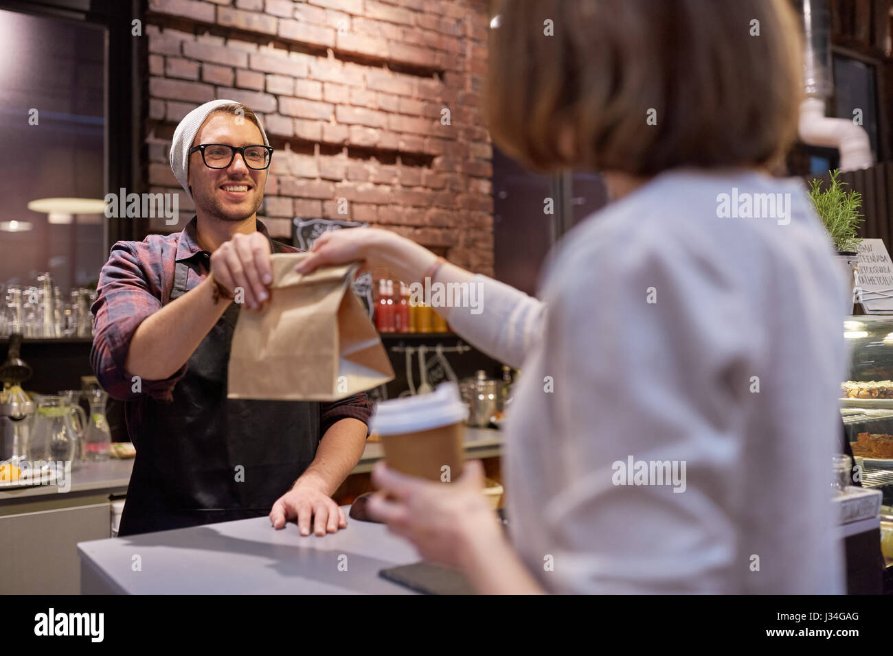 Frau, die Papiertüte vom Verkäufer im café Stockfoto