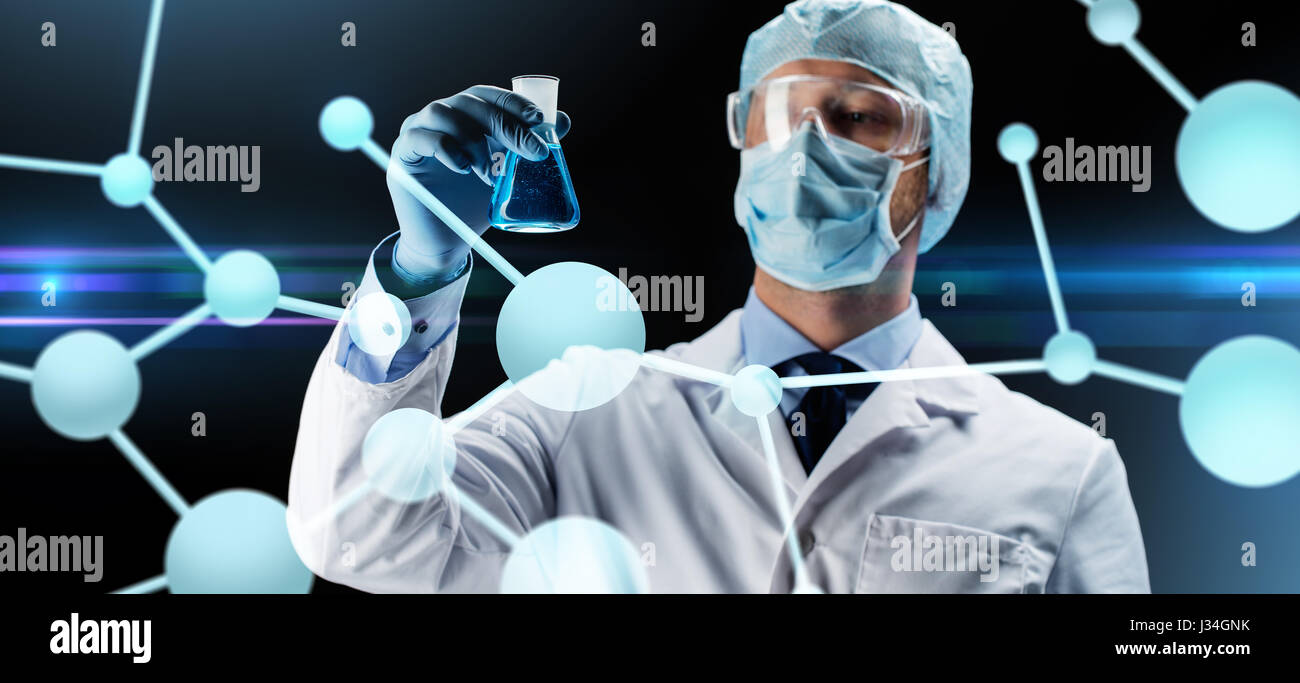 Wissenschaftler in Maske hält Kolben mit chemischen Stockfoto