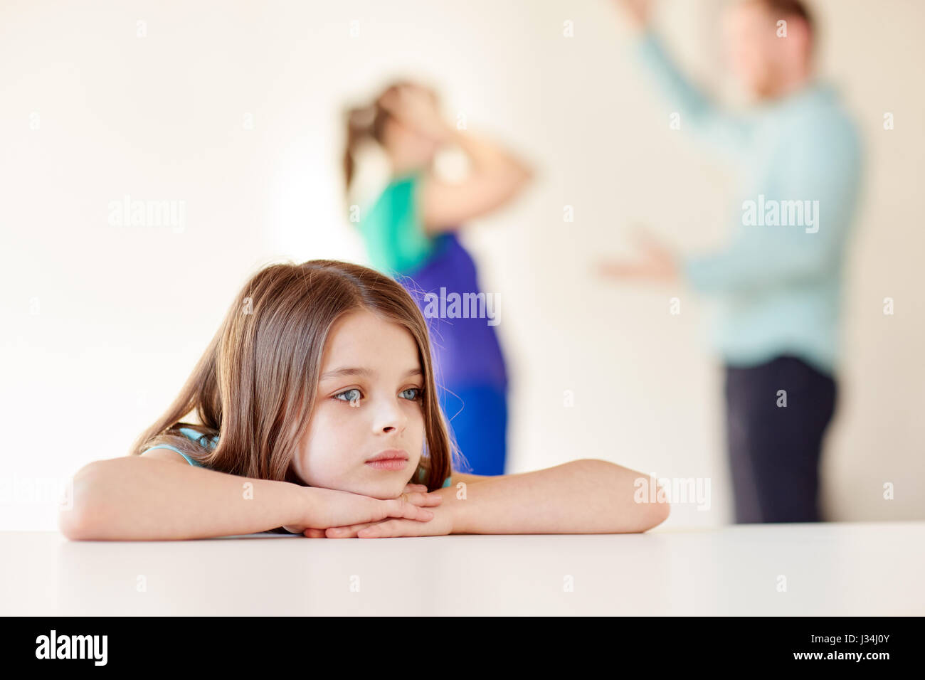 schöne traurige Mädchen und Eltern streiten zu Hause Stockfoto