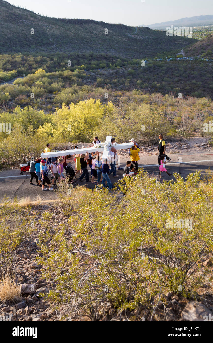 Tucson, Arizona - Teilnehmer in einem jährlichen Karfreitags-Prozession tragen ein großes Kreuz Sentinel Berg hinauf. Die Prozession hält für Stationen von der Stockfoto