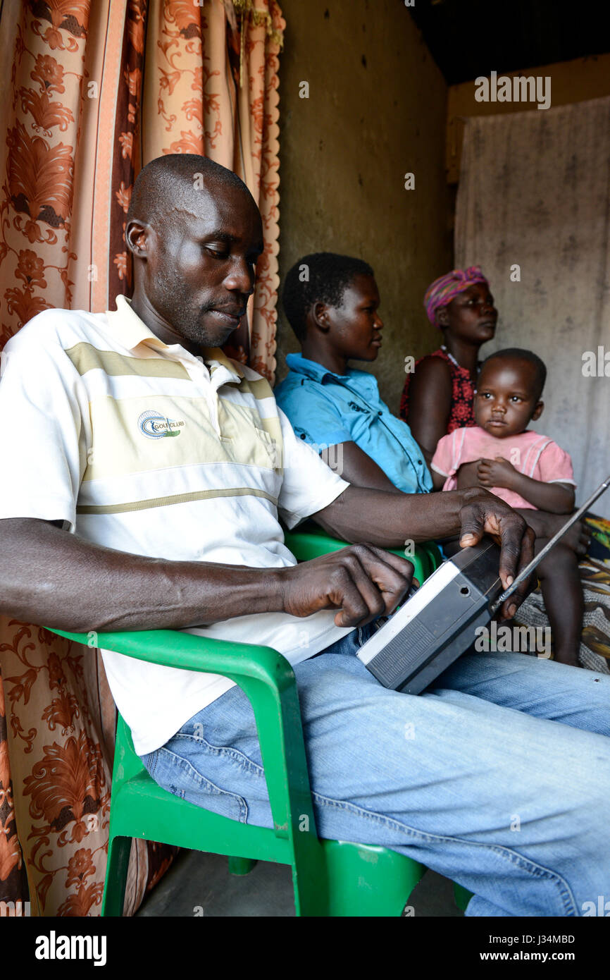 UGANDA, Arua, Dorf Onduparaka, Mann und Familie hören radio Stockfoto