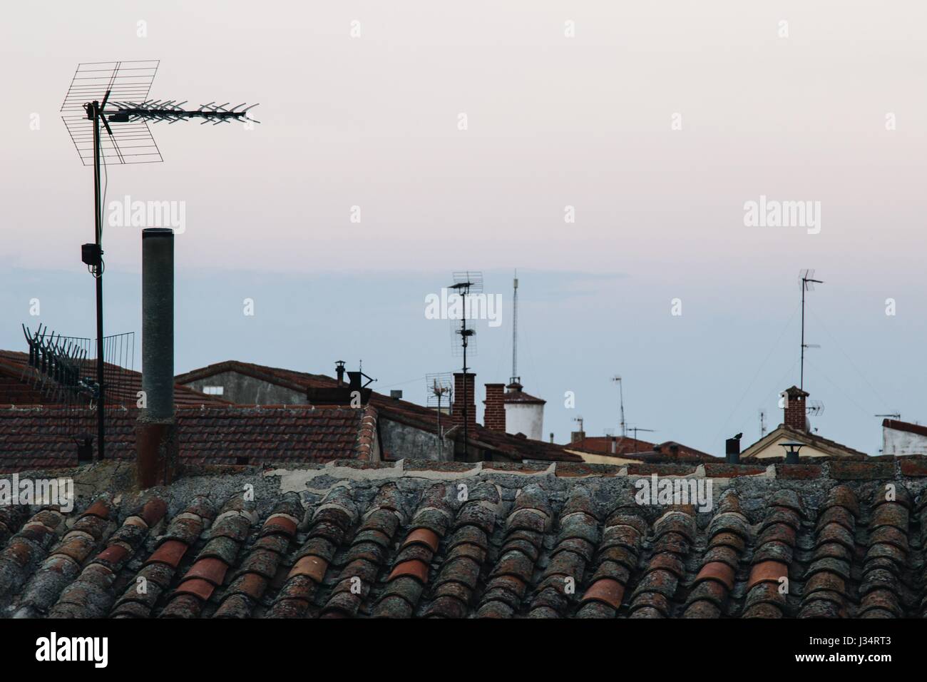 TV-Antennen über Dächer in spanischen Dorf bei Sonnenuntergang Stockfoto