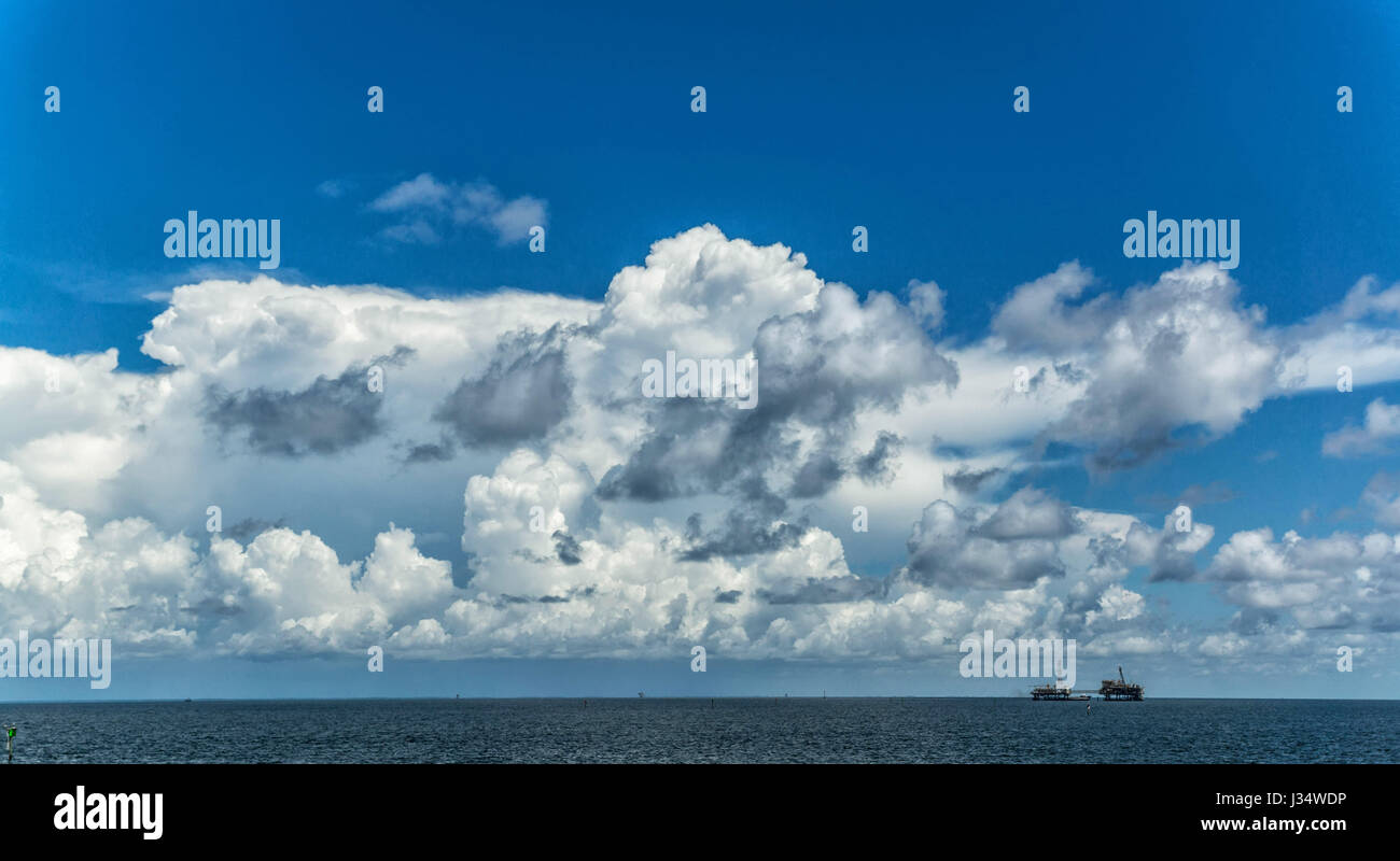 Blauer Himmel und Wolken über Mobile Bay in Alabama mit einer Offshore-Öl-Bohrinsel. Stockfoto