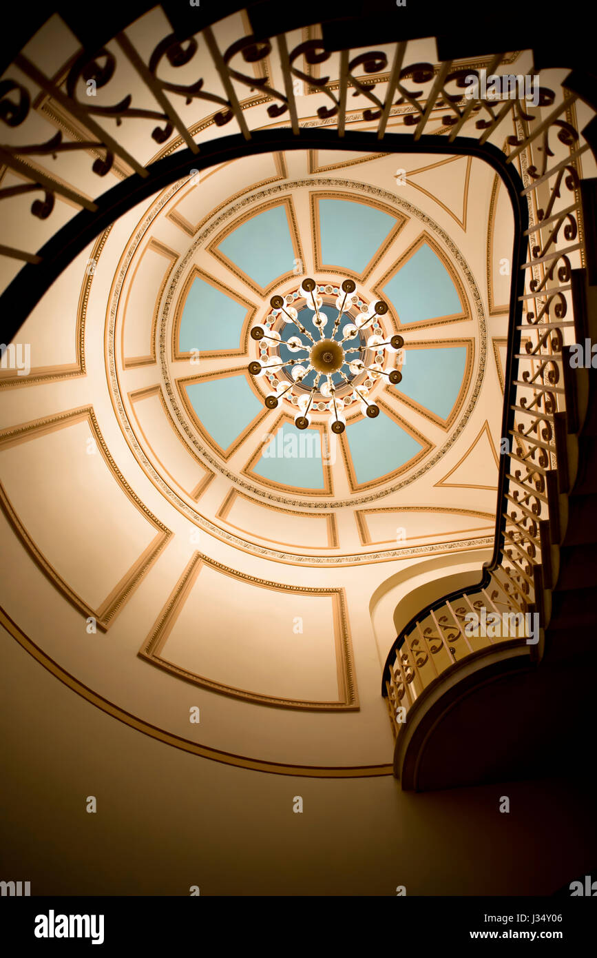 Eine Wendeltreppe mit Balkonen und geschnitzten schmiedeeisernen Balustraden auf den Weg der herrlichen Kunst bemalten Kuppel Decke mit Kristall-Kronleuchter. Stockfoto