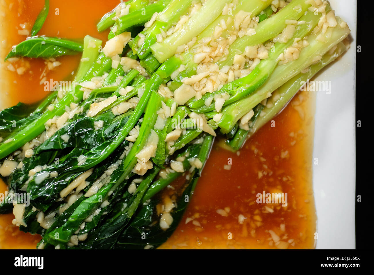 Chinesischer Brokkoli mit Austernsauce schwarzer Hintergrund Stockfoto