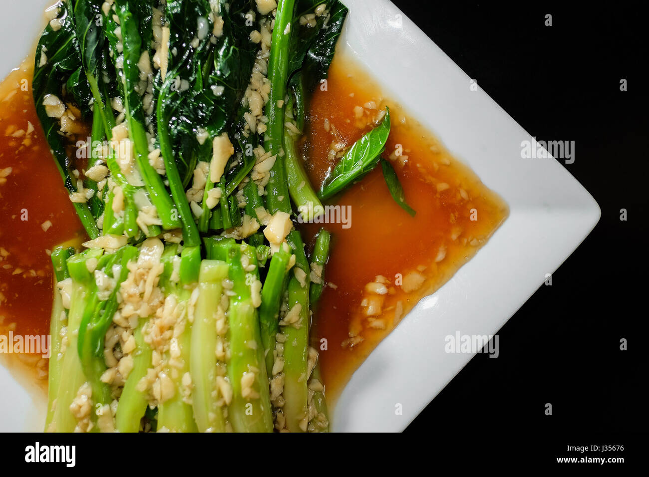 Chinesischer Brokkoli mit Austernsauce schwarzer Hintergrund Stockfoto
