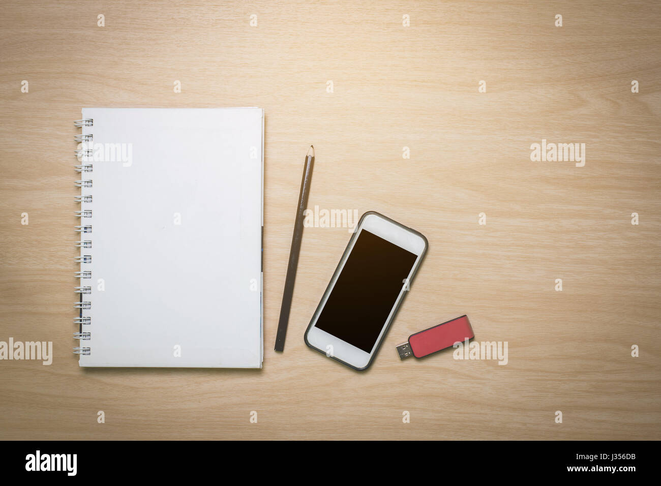 Draufsicht Notebook, Smartphone, Bleistift, Flash-Laufwerk auf dem Schreibtisch ist eine Holzoberfläche mit Textfreiraum Stockfoto
