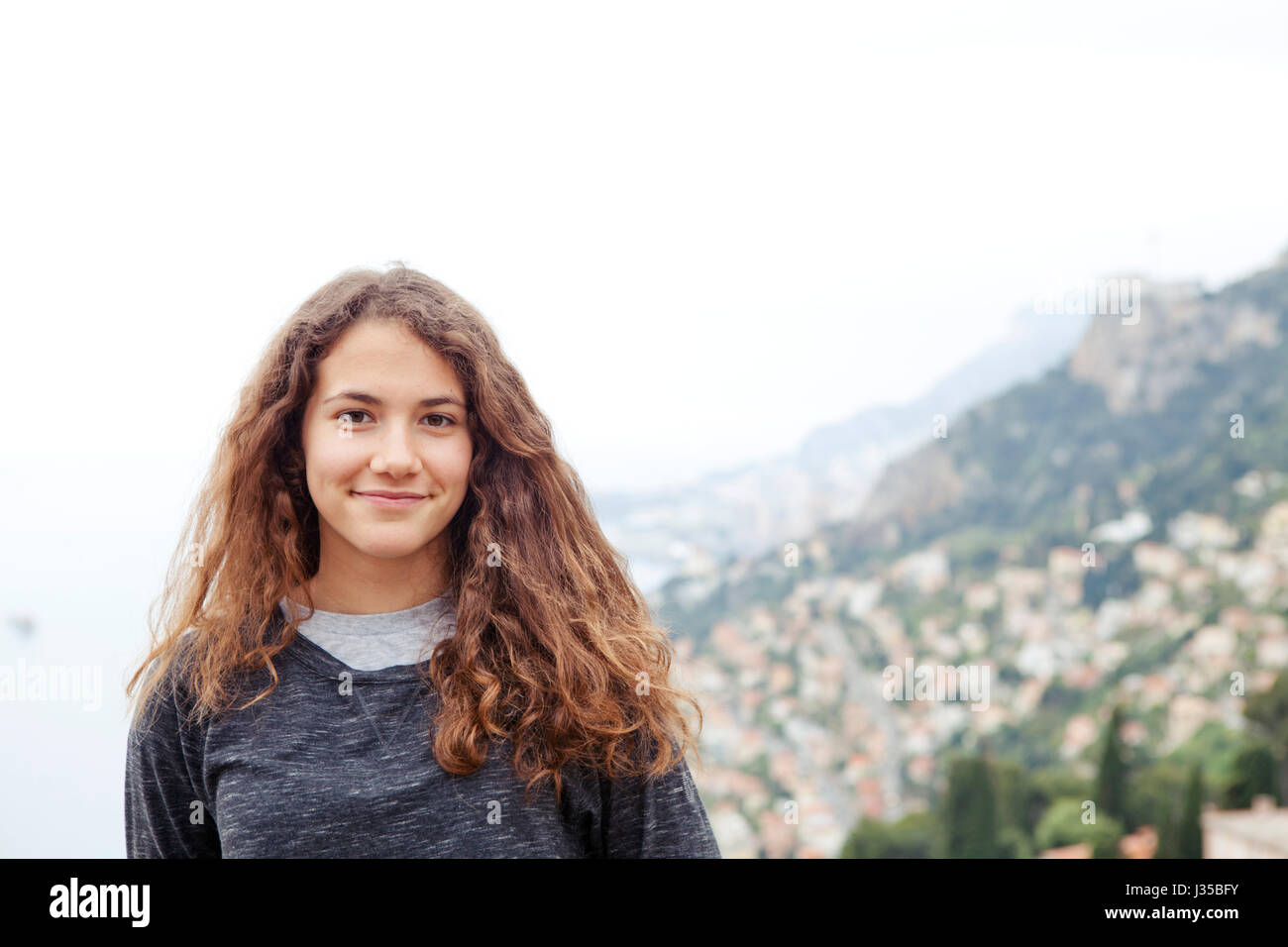 Junges Mädchen in Roquebrune mit Monte-Carlo-Küste im Hintergrund Stockfoto