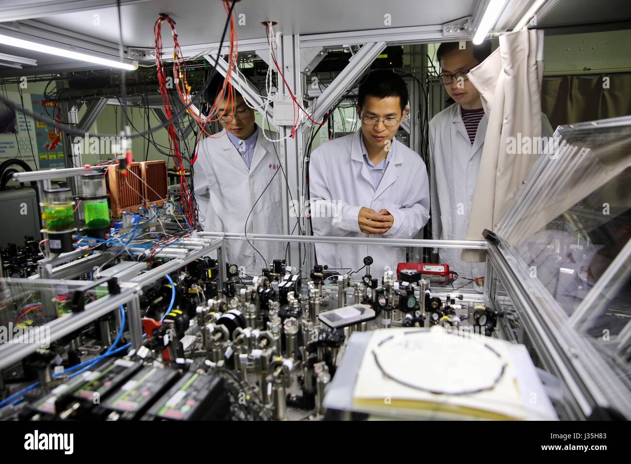 Shanghai, China. 3. Mai 2017. Professor Lu Chaoyang (C) der das University of Science and Technology of China prüft den Betriebszustand der Quanten-Rechenmaschine mit seinen Schülern in einem Labor in Shanghai, Ost-China, 3. Mai 2017. Chinesische Wissenschaftler haben das weltweit erste Quantum Rechenmaschine, die weit über die frühen klassischen-- oder konventionelle--Computer hinausgeht ebnet den Weg für die ultimative Verwirklichung der Quantencomputer gebaut. Bildnachweis: Jin Liwang/Xinhua/Alamy Live-Nachrichten Stockfoto