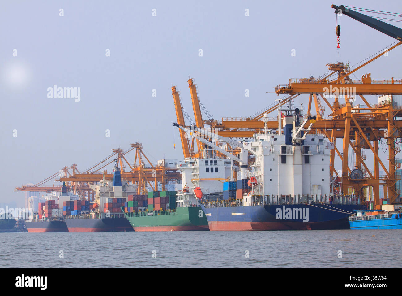 kommerzielle Containerschiff auf Port nutzen für den Wassertransport und Schiff Hof Kran verladen Güter Stockfoto