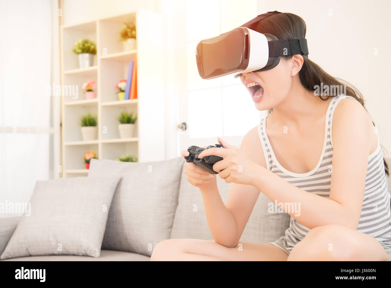 Glückliche junge Frau spielt Video-Spiel in 3D virtual-Reality-Simulator mit Kopfhörer. Gemischte Rassen asiatische chinesische Modell. Stockfoto
