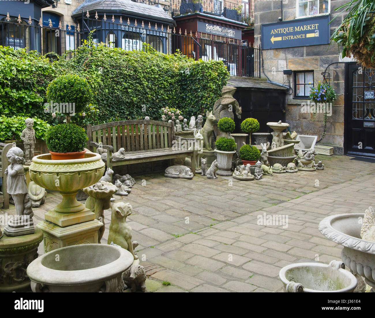 Gepflasterten Innenhof eines Ladens in Montpellier Mews in Montpellier, Harrogate, Yorkshire, Gartenverzierungen, einschließlich eine groteske Punch and Judy zu verkaufen. Stockfoto